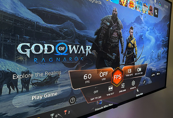 תקריב של מסך טלוויזיה המציג את תפריט המשחק "God of War: Ragnarok" עם אפשרויות לשינוי הגדרות FPS והחלפת VRR.